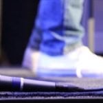A foot with a microphone in the foreground