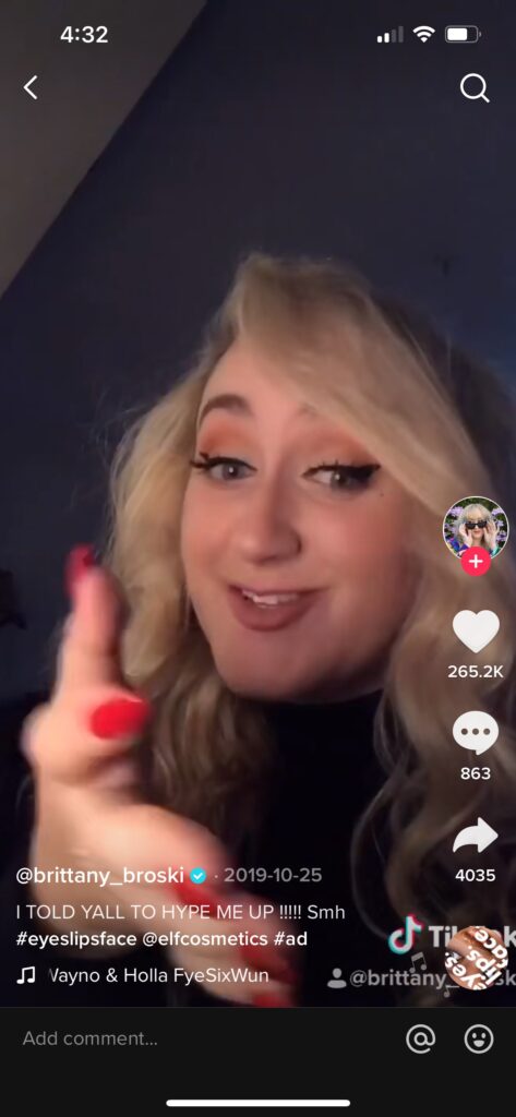 Screenshot of a TikTok video by Brittany Broski. She is wearing makeup and has her down and curly. She is looking at the camera.